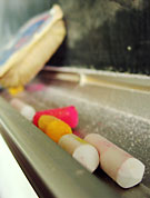 Kritor i olika färger i rännan nedanför svarta tavlan i ett klassrum.