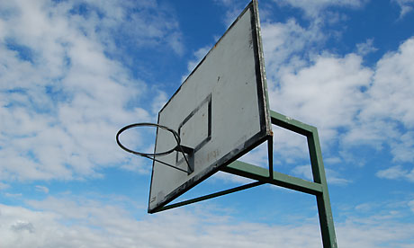 En basketkorg utan nät mot en blå himmel med vita molnslöjor