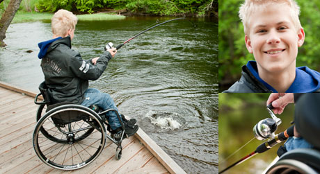 Axel Wernås sitter i rullstol på den tillgängliga bryggan och har just fått en lax på kroken.
