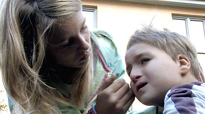Flicka tröstar pojke. Bild från filmen Så himla annorlunda.
