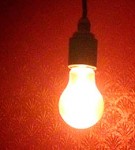 Ensam glödlampa i mörkt rum
