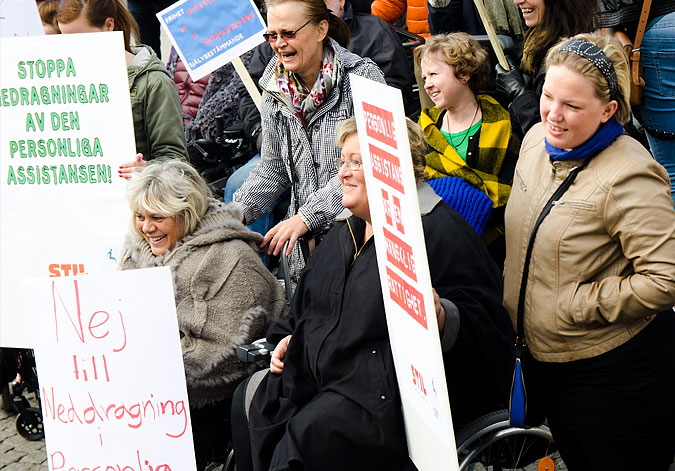 Demonstration under devisen Stop disability cuts. Bilden visar några demonstranter med plakat.