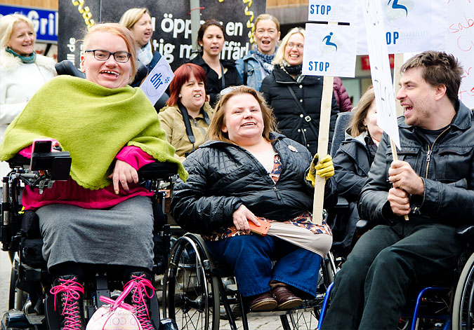 Demonstration under devisen Stop disability cuts. Bilden visar några demonstranter som skanderar.
